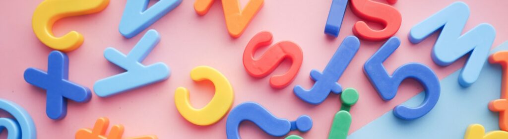 a pile of plastic letters and numbers on a pink and blue background