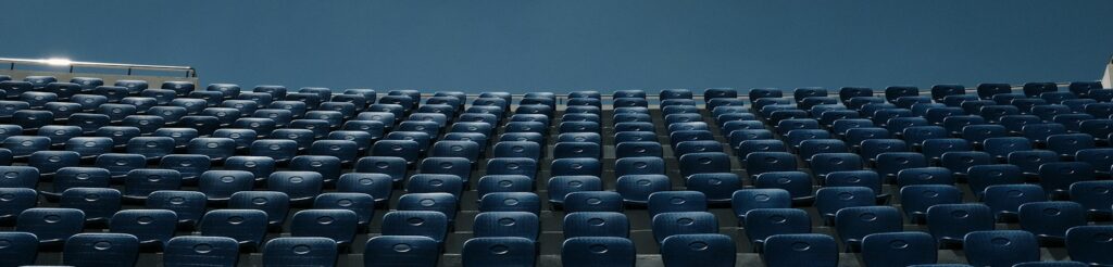 a stadium filled with blue seats under a blue sky