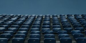 a stadium filled with blue seats under a blue sky